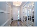 Bright entryway with view into home office and wood-look tile floors at 7853 Roma Dune Dr, Wesley Chapel, FL 33545