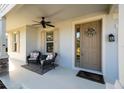 Front porch with seating area and neutral color scheme at 7853 Roma Dune Dr, Wesley Chapel, FL 33545