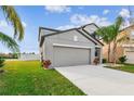 Two-story house with gray siding, two-car garage, and grassy lawn at 11127 Hudson Hills Ln, Riverview, FL 33579