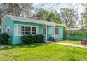 Quaint teal home with white picket fence and lush green lawn at 2600 46Th S St, Gulfport, FL 33711