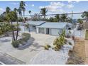 Charming coastal home featuring a metal roof, white picket fence, and tropical landscaping at 2740 E Vina Del Mar Blvd, St Pete Beach, FL 33706