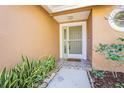 Green front door with storm door and small patio at 2920 Longbrooke Way, Clearwater, FL 33760