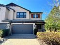 Two-story house with a two-car garage and landscaping at 4899 Isola Ct, Wesley Chapel, FL 33543