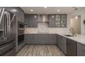 Renovated kitchen with gray cabinets, quartz countertops, and stainless steel appliances at 735 Bonnie Blvd, Palm Harbor, FL 34684
