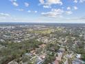 Expansive aerial view of a residential community with tree-lined streets, nearby golf course, and cityscape in distance at 12840 Sophia Cir, Largo, FL 33774