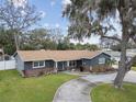 Aerial view of a well-maintained home with a circular driveway, lush lawn, and mature landscaping at 12840 Sophia Cir, Largo, FL 33774