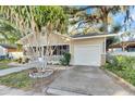 Front view of a yellow house with a screened porch and driveway at 1304 E 32Nd Ave, Tampa, FL 33603