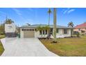 Newly renovated home with a large driveway and tropical landscaping at 141 Singapore Rd, Punta Gorda, FL 33950