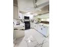 Modern kitchen with white cabinets, marble countertops, and black appliances at 2910 W Burke St, Tampa, FL 33614