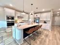 Modern kitchen with white cabinets, quartz countertops, and an island at 3013 61St E Dr, Ellenton, FL 34222