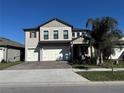 Two-story house with a three-car garage and palm tree in front at 8365 Capstone Ranch Dr, New Port Richey, FL 34655