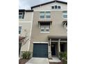 Tan three-story townhome with a dark gray garage door at 840 Tennyson Mill Cir, Tampa, FL 33619