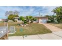 House exterior showcasing a light-beige color, a white garage door, and a manicured lawn at 1004 Orlando Ave, Bradenton, FL 34207