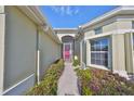 Front entry with walkway, landscaping, and a pink door at 1031 Emerald Dunes Dr, Sun City Center, FL 33573