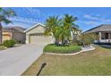 House exterior showcasing a two-car garage and well-manicured landscaping at 1031 Emerald Dunes Dr, Sun City Center, FL 33573