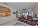 Spacious living room with leather furniture, ceiling fans and lake views at 1031 Emerald Dunes Dr, Sun City Center, FL 33573