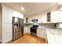 Modern kitchen with white cabinets, stainless steel appliances, and light wood floors at 1582 Budleigh St, Clearwater, FL 33756