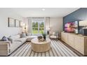 Bright living room featuring a sectional sofa and a round coffee table at 17347 Wheatberry Blvd, Parrish, FL 34219