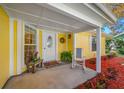 Close up of welcoming porch featuring seating, plants and decorative wreath on front door at 2418 Falcon Ln, Palm Harbor, FL 34683