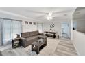 Bright living room features L-shaped sofa, dining area, and wood-look floors at 2622 E Genesee St, Tampa, FL 33610