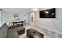 Open living space with L-shaped sofa, dining area, and large TV at 2622 E Genesee St, Tampa, FL 33610