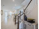 Bright and spacious entryway with staircase, and view into kitchen at 28818 Orange Berry Dr, Wesley Chapel, FL 33543