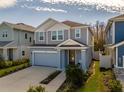 Two-story house with gray and blue siding, two-car garage, and landscaping at 28818 Orange Berry Dr, Wesley Chapel, FL 33543