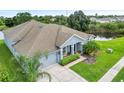 One-story house, gray exterior, two-car garage, and backyard overlooking a pond at 31055 Edendale Dr, Wesley Chapel, FL 33543