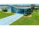 Aerial view of a light blue manufactured home with a carport at 37622 New Horizons Blvd, Zephyrhills, FL 33541