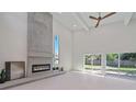 Bright living area with a large concrete fireplace, sliding glass doors, and hardwood floors at 513 Hand Ave, Sarasota, FL 34232