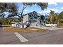 Two-story house with gray and blue exterior, and a white fence. Side yard view at 7321 Mount Vernon Rd, Tampa, FL 33625