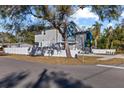 Two-story house with gray and blue exterior, and a white fence. Side yard view at 7321 Mount Vernon Rd, Tampa, FL 33625