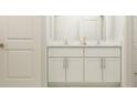 Bathroom with double vanity and white cabinets at 9374 Runaway Breeze Dr, Land O Lakes, FL 34637