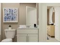 Modern bathroom with white vanity, toilet, and decorative art at 10264 Alder Green Dr, Riverview, FL 33578