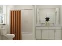 Bathroom with a tub shower, white vanity, and orange curtain at 11562 E 71St Ter, Palmetto, FL 34221