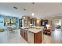 Modern kitchen with an island, stainless steel appliances, and light tile floors at 205 Silver Falls Dr, Apollo Beach, FL 33572