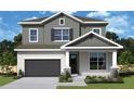 Two-story house with gray siding, dark garage door, and landscaping at 3218 21St N St, St Petersburg, FL 33713