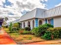 White building with blue accents, metal roof, and landscaping at 4231 Tamargo Dr # 3, New Port Richey, FL 34652