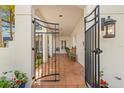 Covered entry with arched walkway, tile flooring, and wrought iron gate at 4306 W Swann Ave, Tampa, FL 33609