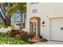 Front entry with ornate gate, tiled walkway, and mature plantings at 4306 W Swann Ave, Tampa, FL 33609