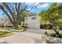 White two-story house with a large driveway and mature trees at 4306 W Swann Ave, Tampa, FL 33609