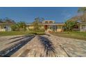 House exterior featuring a large paved driveway and landscaping at 783 Placido Ne Way, St Petersburg, FL 33704