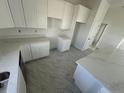 White kitchen with marble countertops at 10658 Rainsville St, Port Charlotte, FL 33981