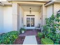 Inviting front porch with double doors, brick columns, and lush landscaping at 11440 Baronwood Ct, Hudson, FL 34667