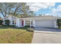 Landscaped front yard with spacious driveway and house exterior at 13214 Moran Dr, Tampa, FL 33618