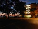 Evening view of condo building with lit balconies and surrounding trees at 2700 Bayshore Blvd # 11302, Dunedin, FL 34698