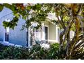 Inviting front porch with seating, partially visible home entrance, and lush landscaping at 3653 Kings Rd # 101, Palm Harbor, FL 34685