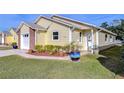 Attractive yellow house showcasing a side view and lush landscaping at 37347 Derbyshire Dr, Zephyrhills, FL 33542