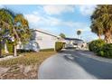 Single story home with a circular driveway and palm trees at 713 Gran Kaymen Way, Apollo Beach, FL 33572