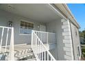 Private balcony with white railings and exterior door at 7713 Hillside Ct # 201, Hudson, FL 34667
